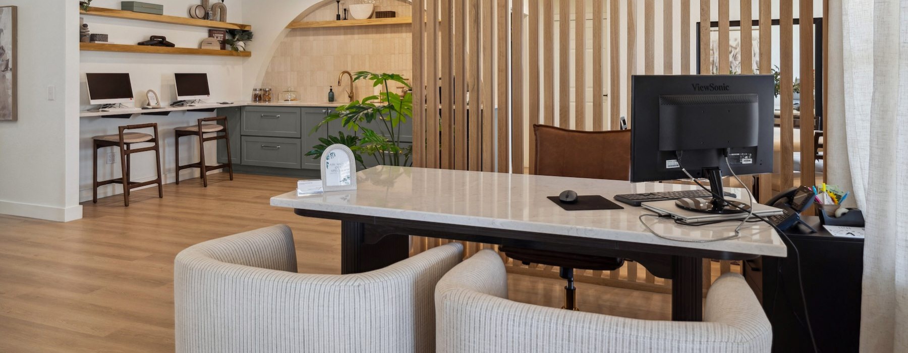 a leasing office front desk with chairs and a computer