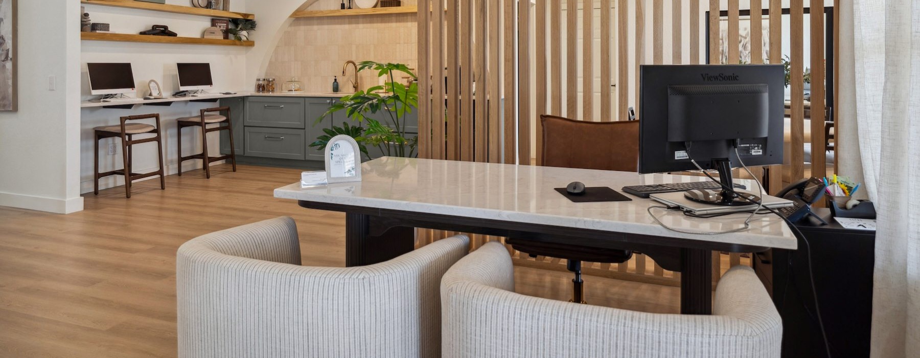 a leasing office front desk with chairs and a computer